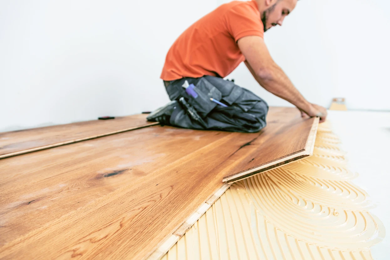 Craftsmen lay parquet flooring in a modern house
