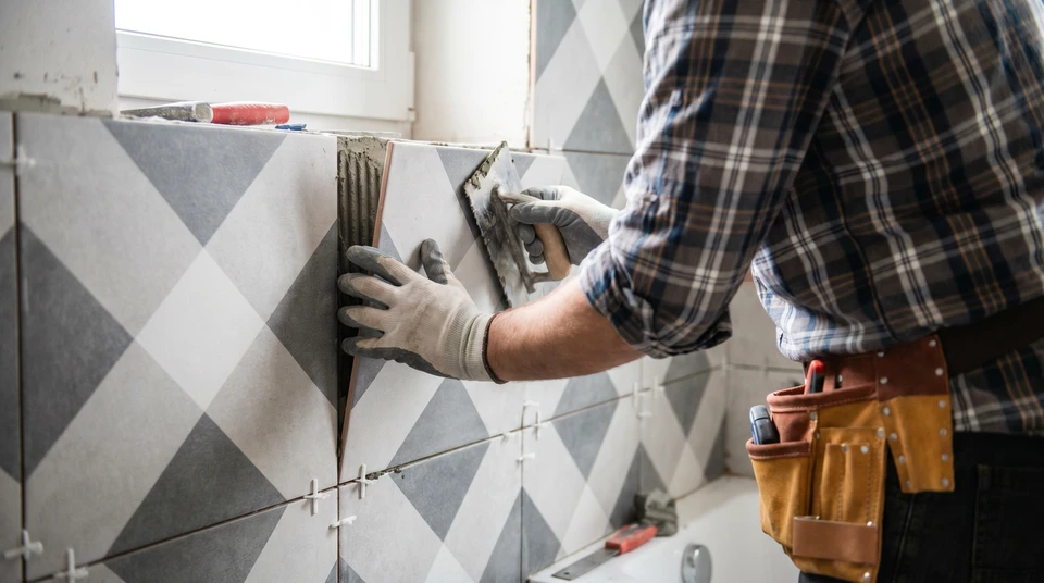 Chantier de construction avec outils de maçonnerie disposés contre un mur en béton brut