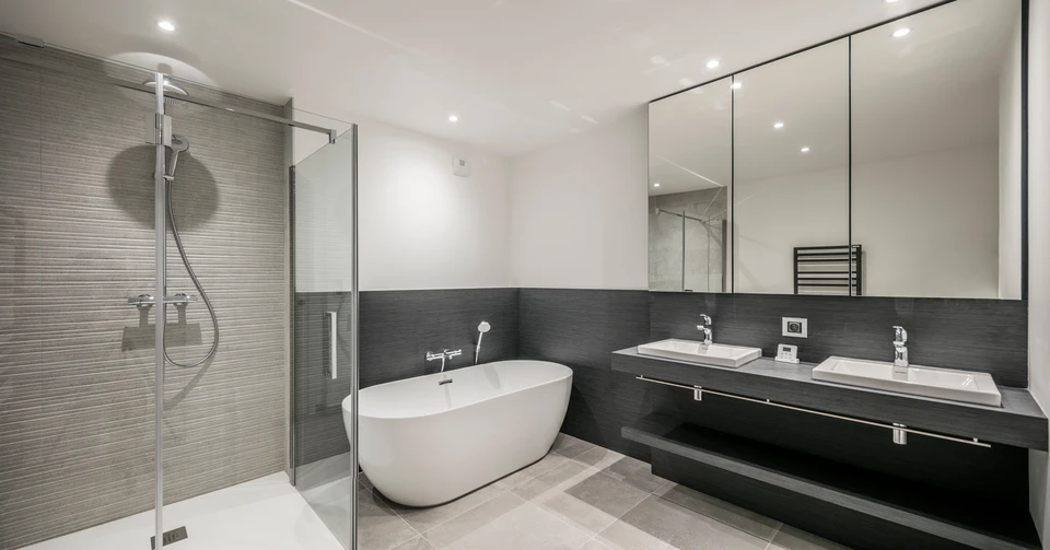 Salle de bain moderne minimaliste avec baignoire ovale en bois naturel, vasque suspendue blanche, robinetterie chromée au sol